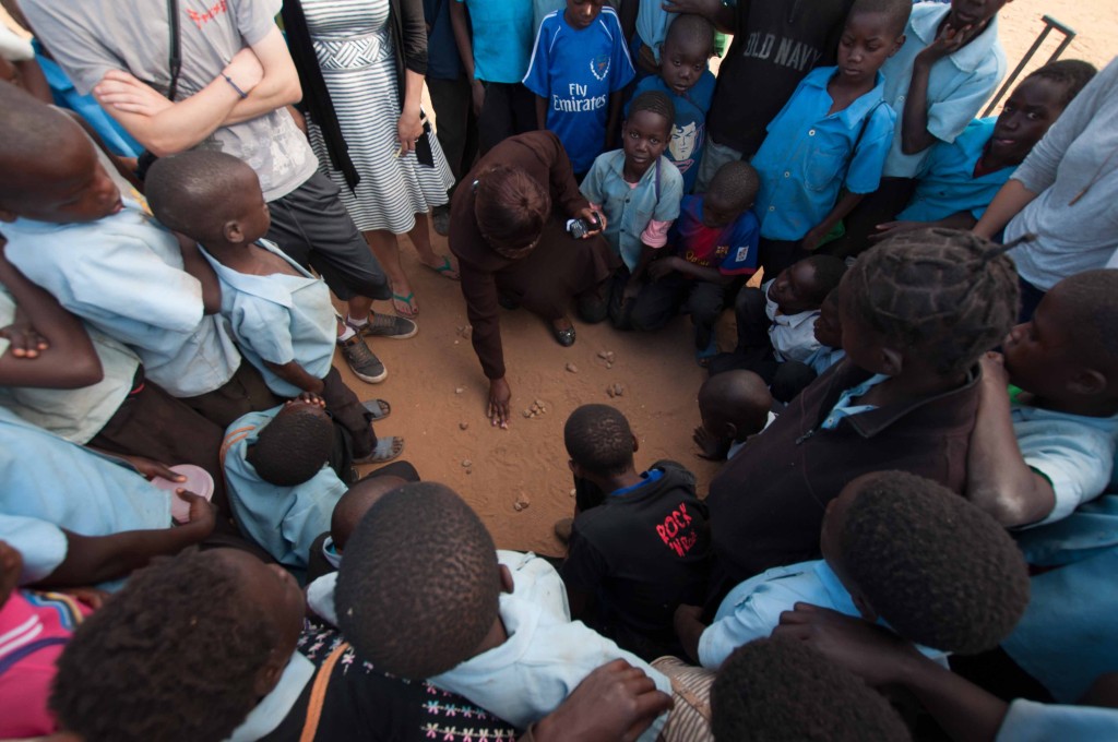 A Dwankhozi teacher plays a local game in the sand with the students.